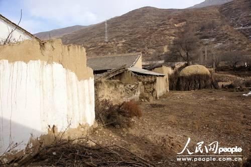 甘肃漳县大草滩乡新联村，“遮羞墙”内农户破败的房屋和院墙与新墙形成鲜明对比（人民网记者 高翔 张鹏 隋欣 摄）