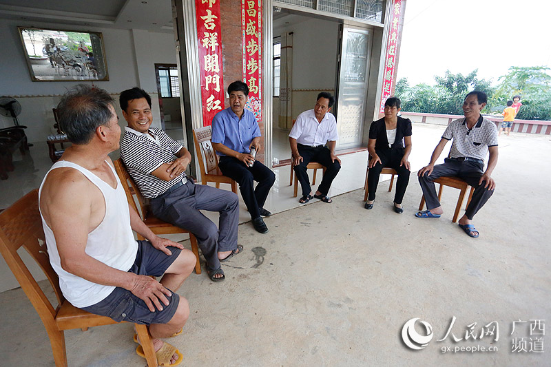 铁山港区委书记刘志明与回建区村民围坐交流(罗世立/摄)