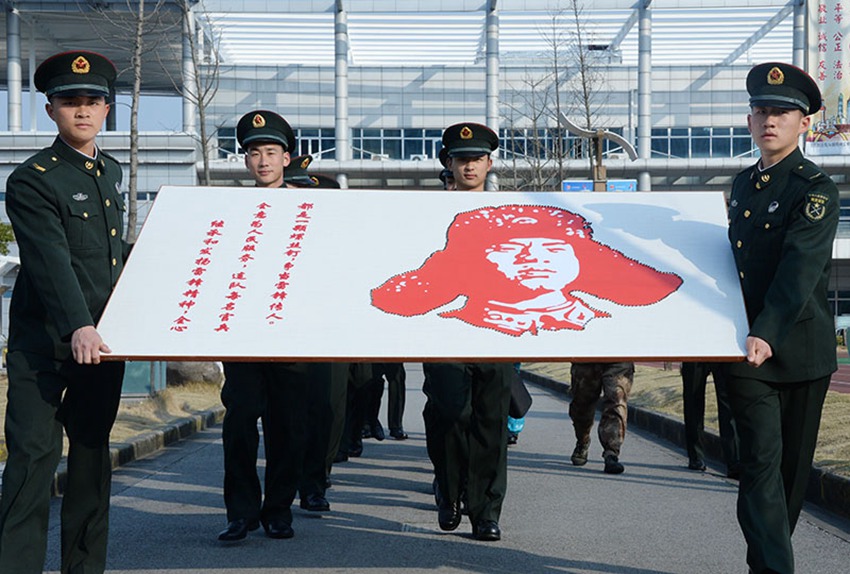 今天上午，在上海市浦东新区航头镇雷锋广场，随着藏族战士扎西吉村和志愿者汪祯懿共同把最后2颗螺丝钉拧在画板上，一幅镶嵌着百余颗螺丝钉的雷锋画像跃然成形。（李恺明 程关洲）