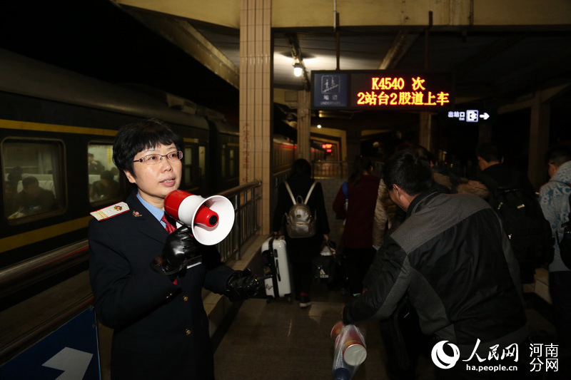 洛阳车务段三门峡车站客运班组主任客运组织员朱雪梅引导旅客出站。赵震宇摄