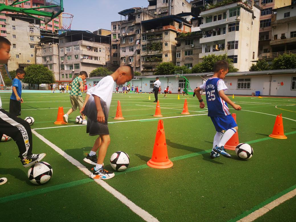 重庆彭水参与暑期托管的孩子正在学校操场踢球。彭水县教委供图