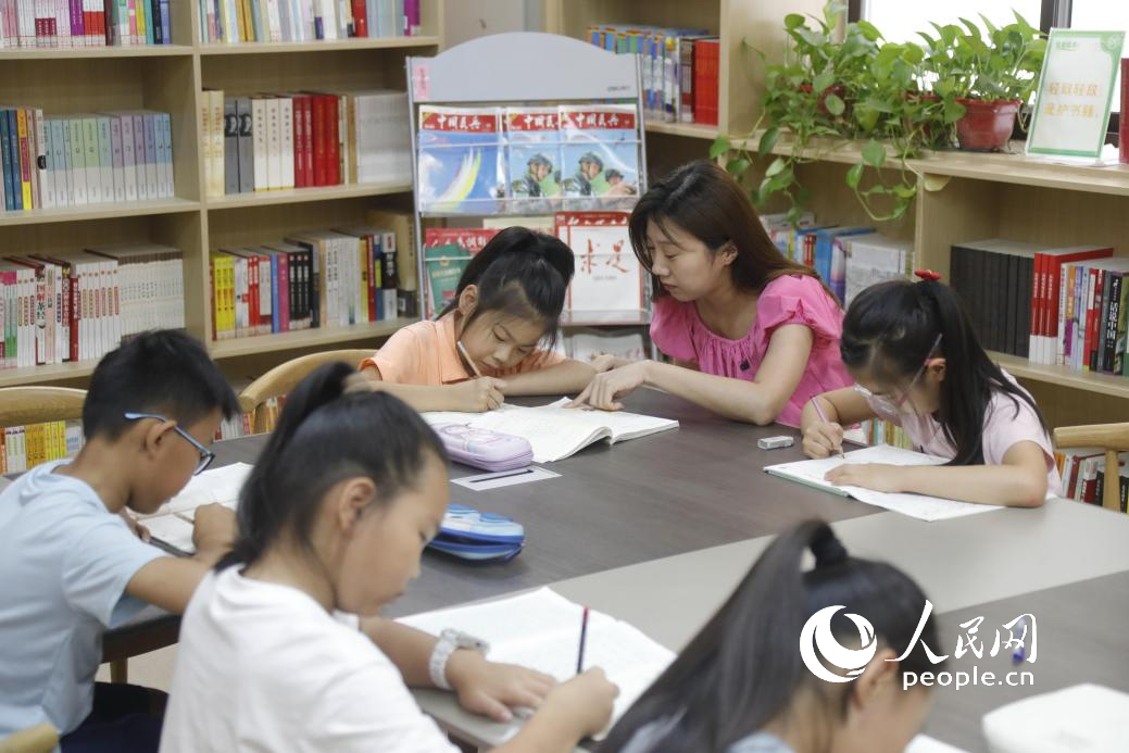 大学路街道嵩山社区的暑托班上，小朋友们在老师的辅导下做暑假作业。人民网记者 慎志远摄